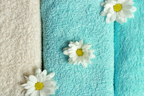 Clean soft towels with flowers, top view