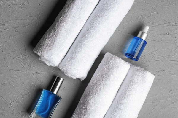 Gerollte Saubere Weiche Handtücher Mit Kosmetik Auf Grauem Hintergrund — Stockfoto