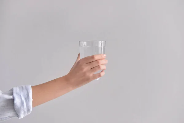 Weibliche Hand Mit Einem Glas Süßwasser Auf Hellem Hintergrund — Stockfoto