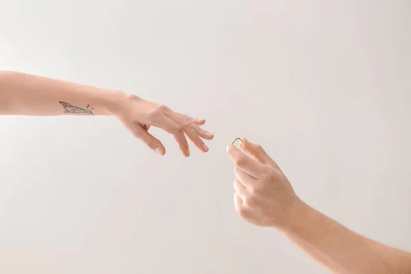 Mann Legt Verlobungsring Finger Der Verlobten Auf Hellen Hintergrund — Stockfoto