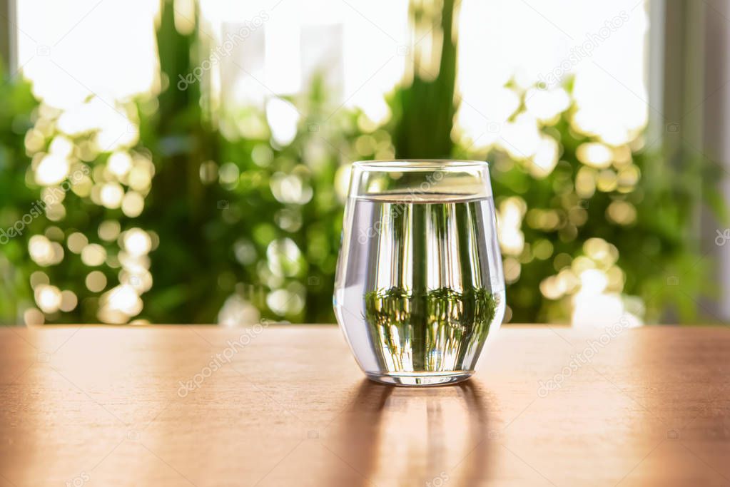 Glass of fresh water on wooden table