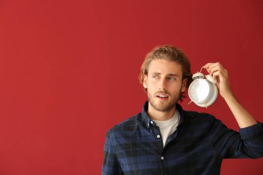 Çalar saat renk arka plan üzerinde olan genç adam