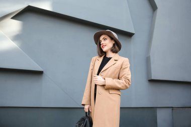 Gri duvar açık havada yakınındaki güzel moda kadın