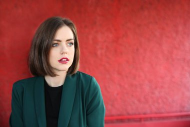 Kırmızı duvarının yakınında güzel moda kadın