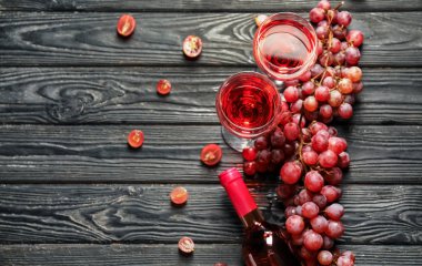 Şişe, bardak lezzetli şarap ve üzüm ahşap masa üzerinde