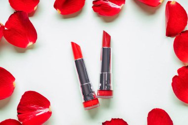 Beyaz zemin üzerine gül yaprakları ile kırmızı rujları