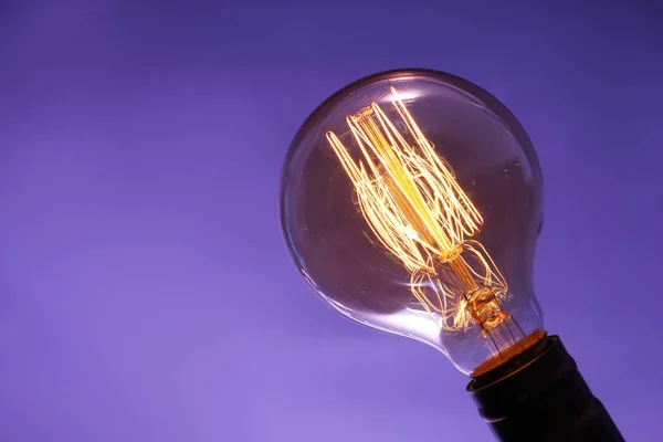 Glowing Old Light Bulb Color Background Stock Image