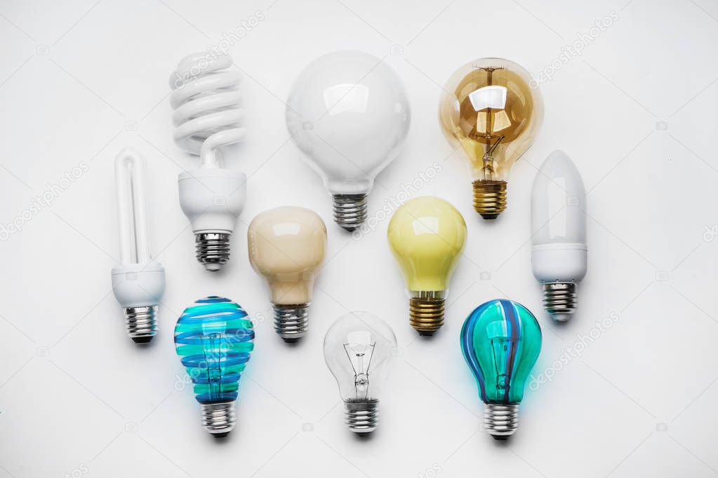 Composition with different light bulbs on white background