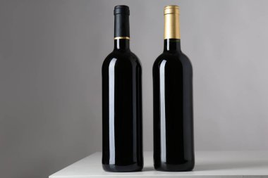 Gri arka plan üzerinde kırmızı şarap şişeleri