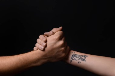 Erkek ve kadın koyu arka plan üzerinde elele