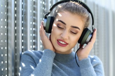 Güzel genç kadın müzik açık havada için dinleme