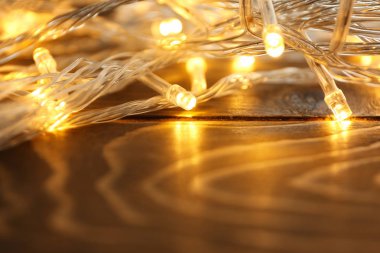 Ahşap masa, closeup parlak Noel ışıkları