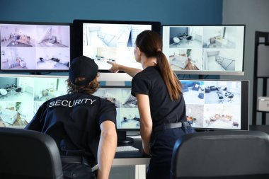 Güvenlik görevlileri gözetleme odasındaki kameraları izliyorlar.