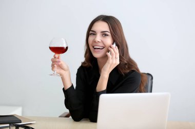 Güzel genç kadın ofiste şarap içme