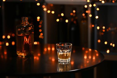 Cam ve şişe viski bulanık ışıklar karşı karanlık masada