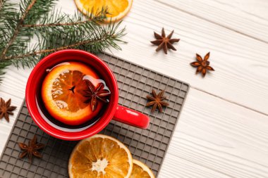 Beyaz ahşap zemin üzerinde lezzetli mulled şarap bardağı