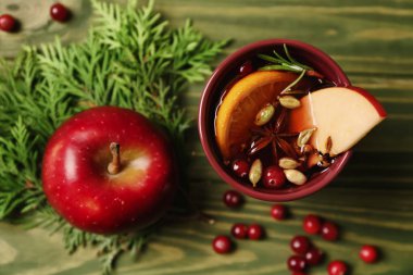 Fincan lezzetli mulled şarap ve ahşap arka plan üzerinde elma