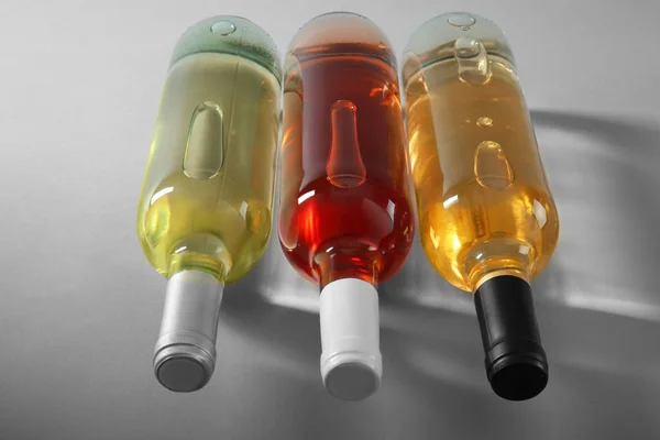 Botellas Con Diferentes Tipos Vino Sobre Fondo Gris — Foto de Stock