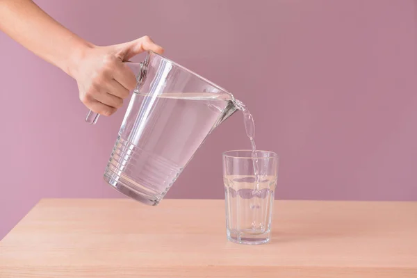 Woman Pouring Fresh Water Jug Glass Wooden Table — Stock Photo, Image