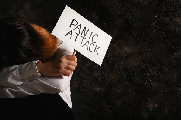 沮丧的妇女拿着纸与文本恐慌攻击在灰色的格格背景 — 图库照片