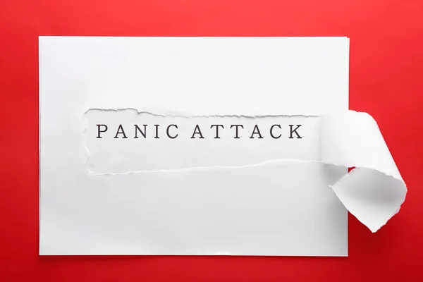 Text PANIC ATTACK appearing behind torn paper on color background