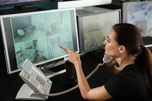 Ochroniarz Rozmawia Przez Telefon Podczas Monitorowania Nowoczesnych Kamer Cctv Pokoju — Zdjęcie stockowe