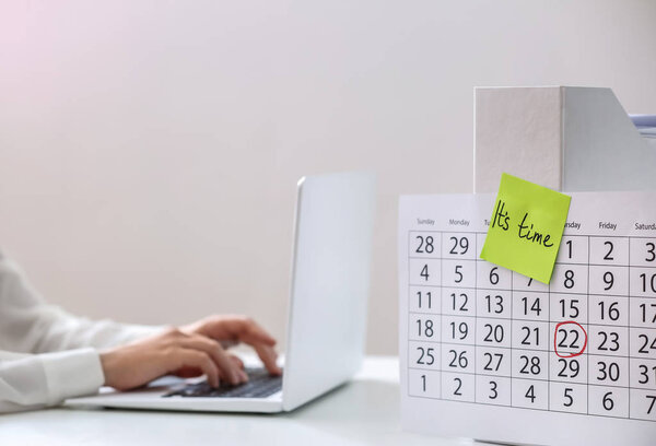 Бумажный лист с текстом ВРЕМЯ на календарь и женщина, работающая за столом. Концепция срока действия
