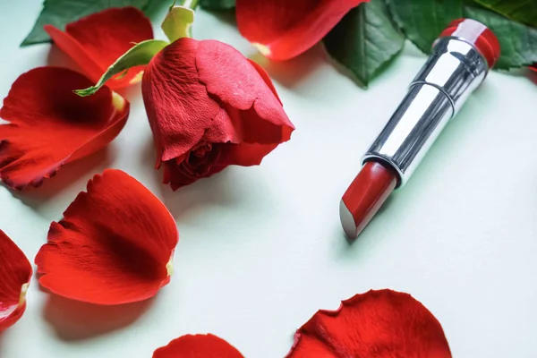 白い背景の上のバラの花びらと赤い口紅 — ストック写真