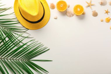 Deniz kabuklarını, şapka ve tropikal kompozisyonu beyaz arka plan üzerinde bırakır