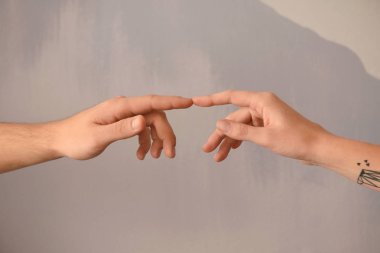Erkek ve kadın parmakları gri arka plan üzerinde dokunmadan
