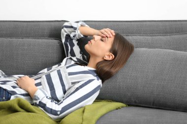 Evde baş ağrısı çeken bir kadın.