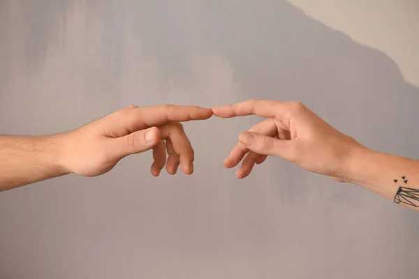 Hombre y mujer tocando dedos sobre fondo gris —  Fotos de Stock