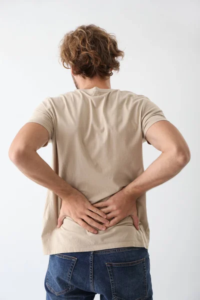 Young Man Suffering Back Pain Light Background — Stock Photo, Image