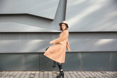 Gri duvar açık havada yakınındaki güzel moda kadın