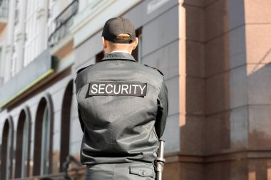 Erkek güvenlik görevlisi açık havada, arkadan görünüm