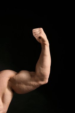 Koyu arka plan üzerinde kas vücut geliştirmeci kol