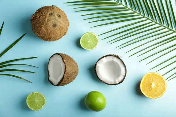 Ripe coconuts, lime and lemon on color background