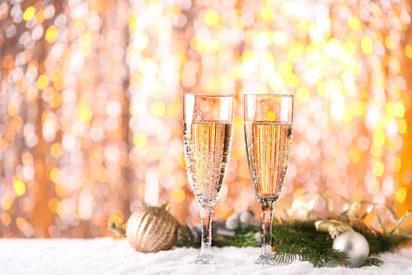 Gläser Champagner Und Weihnachtsdeko Auf Schnee Gegen Verschwommenes Licht — Stockfoto