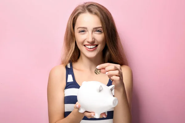 Mujer Joven Poniendo Moneda Alcancía Fondo Color —  Fotos de Stock