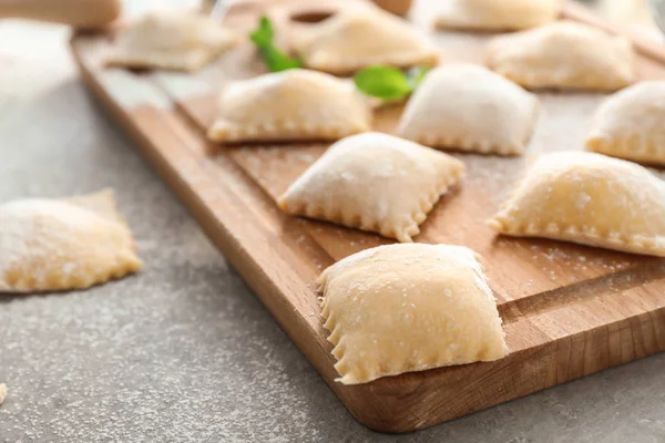 Ahşap tahta ile gri tablo, closeup pişmemiş Mantı