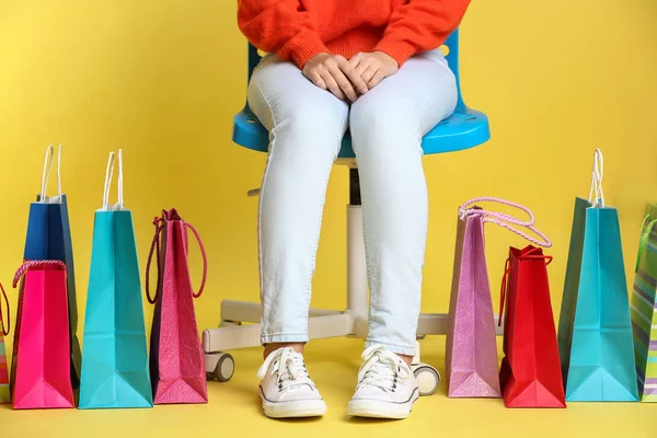 Alışveriş Torbaları Renk Arka Plan Karşı Sandalyeye Oturmuş Olan Güzel — Stok fotoğraf