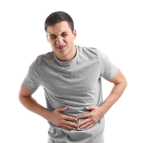 Young man suffering from abdominal pain on white background