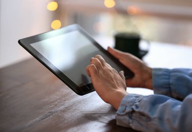 Ahşap masa tablet bilgisayar kullanan kadın