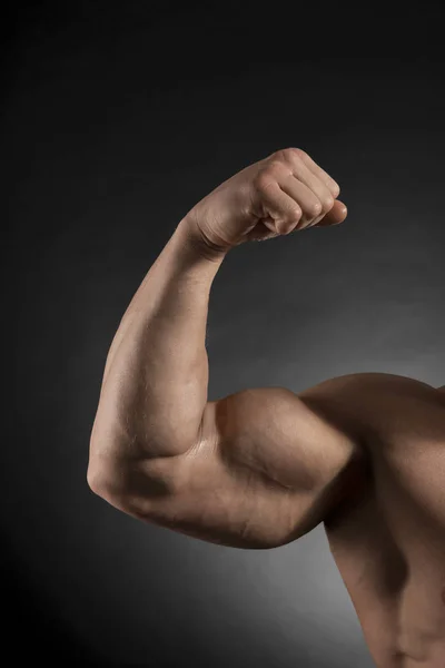 Arm Eines Muskulösen Bodybuilders Auf Dunklem Hintergrund — Stockfoto