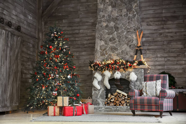 Stylish interior of room with beautiful Christmas tree and fireplace