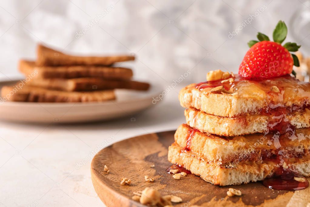Wooden plate with sweet toasts on table, closeup