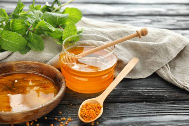 Kase ve koyu ahşap masa üzerinde tatlı bal kavanozu