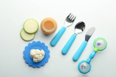 Sağlıklı bebek maması cam kavanoz, çatal bıçak takımı ve beyaz zemin üzerine malzemeler ile düz yatıyordu kompozisyon