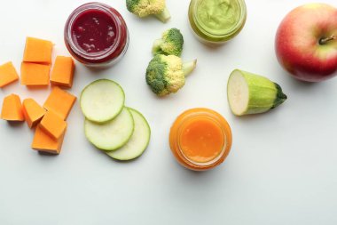 Düz kompozisyon, sağlıklı bebek mamaları ve beyaz arka planda malzemeler.