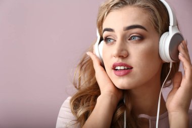 Güzel, genç bir kadın müzik dinliyor.